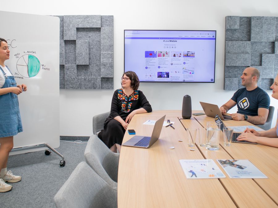 Marketing strategy meeting in a modern office with performance data on screen